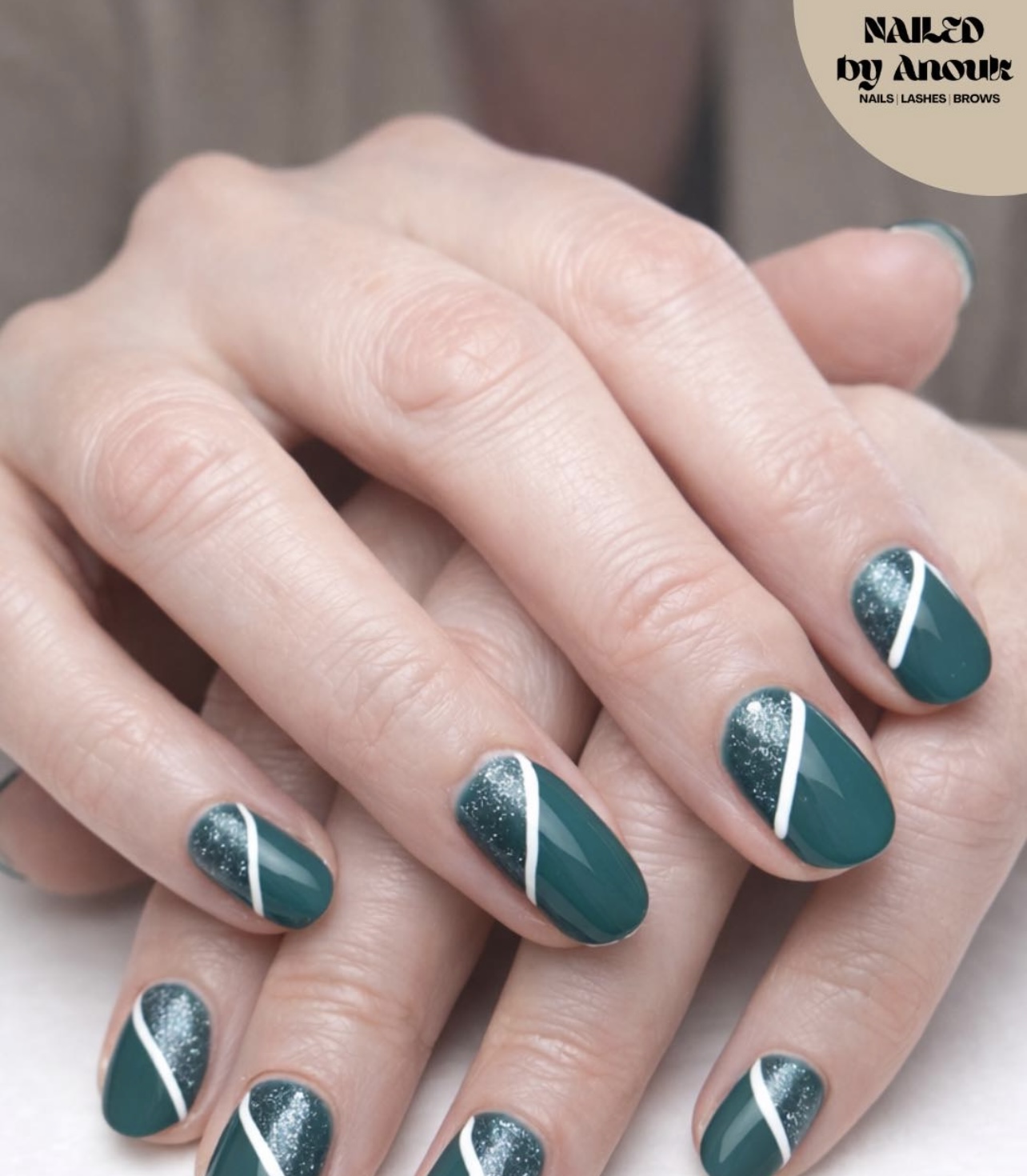 Donkergroene nagels met glitter en een witte diagonale streep