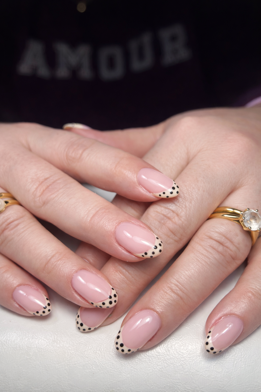 Zachtroze nagels met zwarte stipjes langs de punt