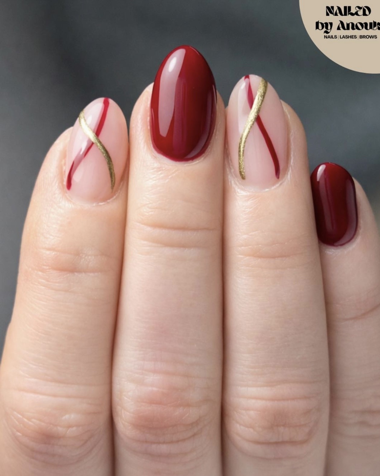Donkerrode nagels met lijnen in rood en goud